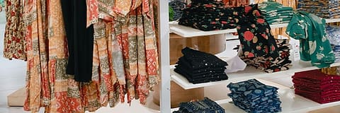 Printed clothing folded and hung on the shelves of a clothing shop.