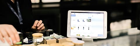 A tablet on a shop counter, open on the shop's own product list.